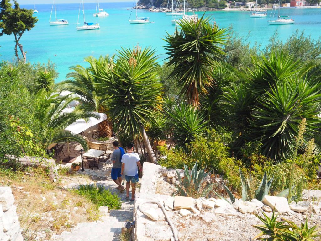 Two boys going down steep steps to taverna at Harami beach Lakka. Copyright © 2017 mapandfamily.com 