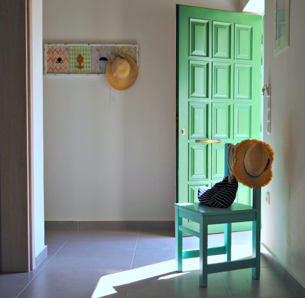 Villa Avra hallway with a green front door and a turquoise  painted chair. Copyright © 2017 mapandfamily.com 