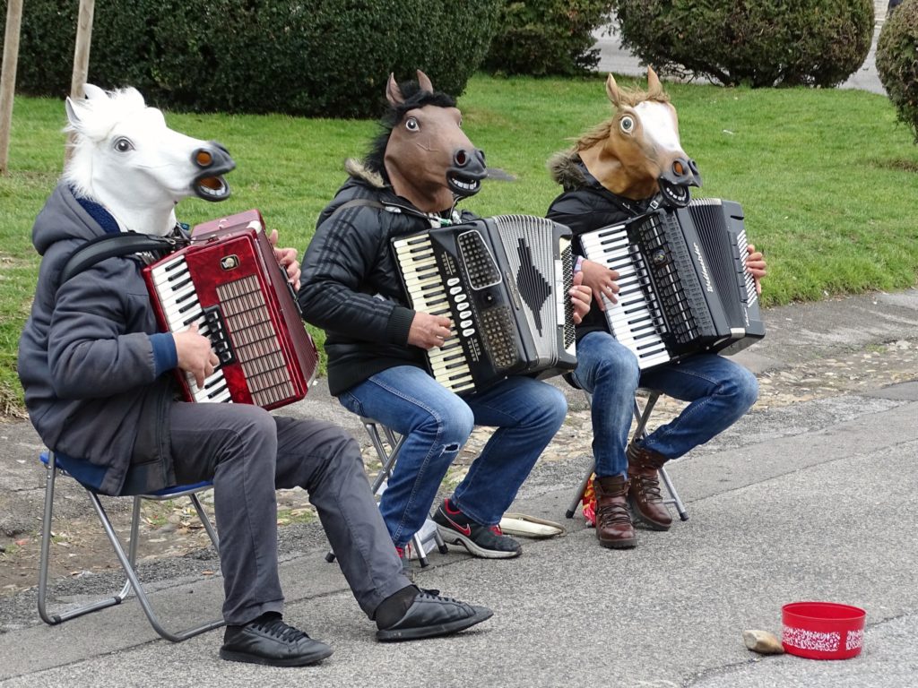 Vienna with teens, buskers playing accordians and wearing horse head masks. copyright©2018 mapandfamily.com 