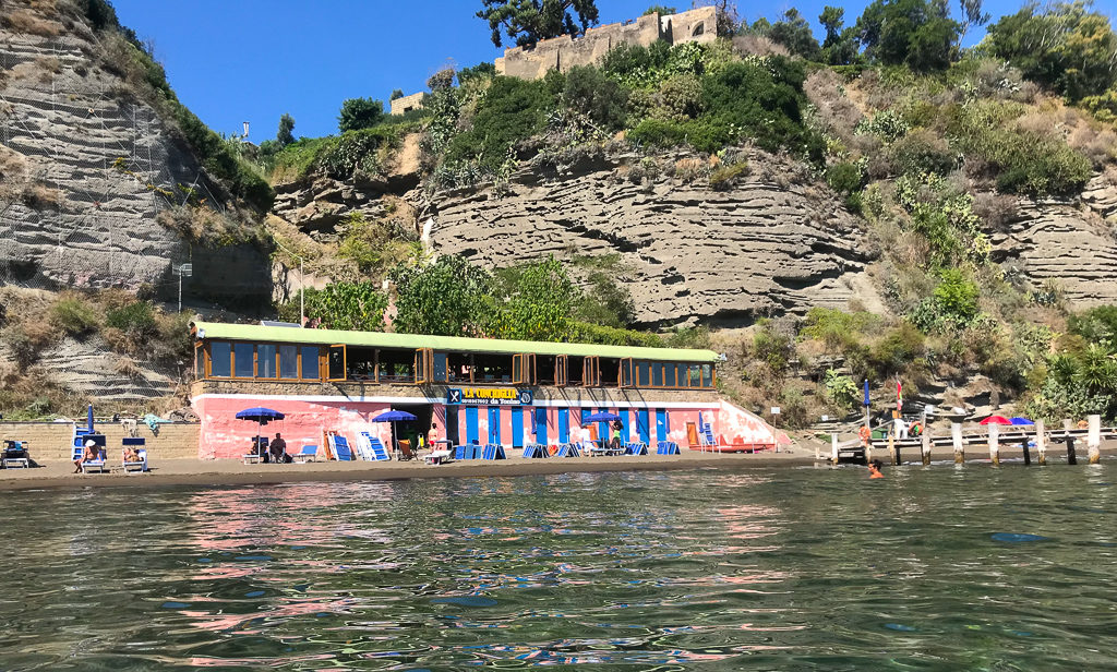 Conchiglia restaurant on Chiaia beach Procida with windows opening out to the beach. Copyright©2019 mapandfamily.com 