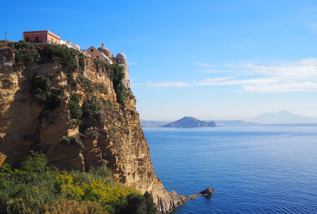 Terra Murata on Procida, Italy. View of headland, blue sky and blue bay of Naples with islands beyond. Copyright©2019 mapandfamily.com 