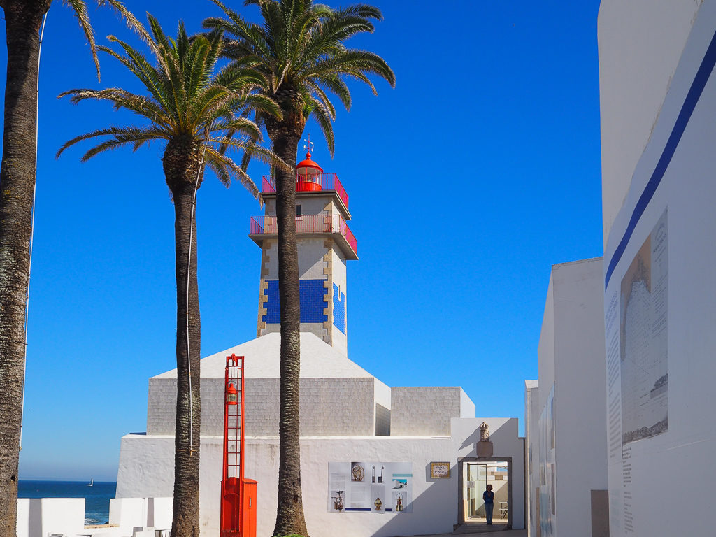 Blue sky and palms with Cascais lighthouse and museum. Copyright ©2019 mapandfamily.com 