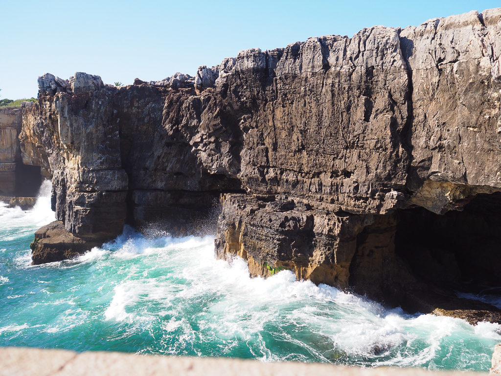 Waves splashing against steep cliffs at Boca d'Inferno, Cascais. Copyright ©2019 mapandfamily.com  