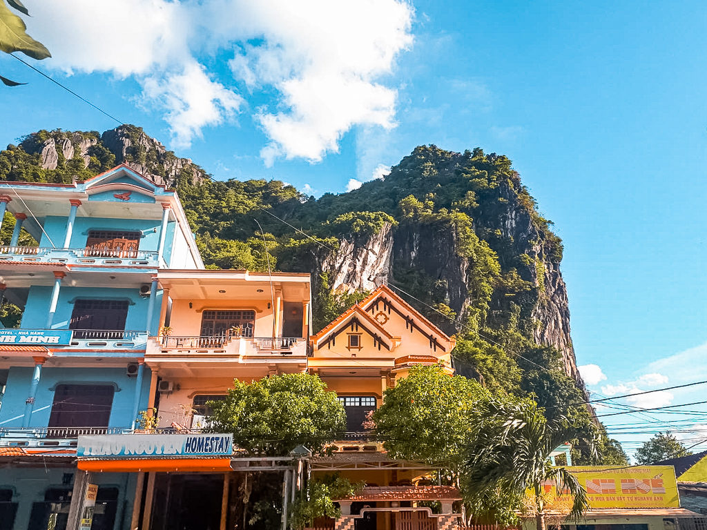 Hanoi to Phong Nha. Buildings and mountains against a blue sky. Copyright ©2019 mapandfamily.com 