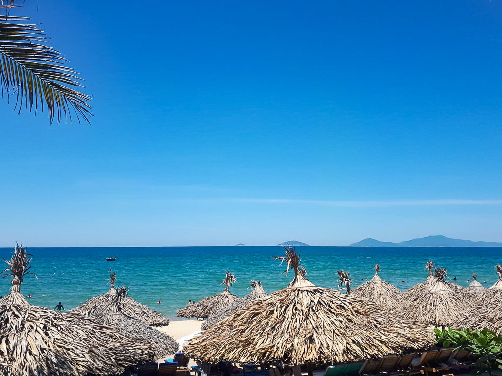 Vietnam highlights: palm fronds and sun shades at An Bang beach. Copyright ©2019 mapandfamily.com 