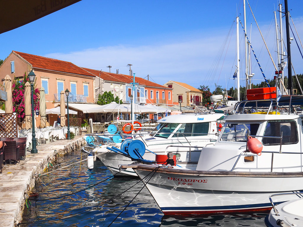 One of the best places to stay in Kefalonia is Fiskardo village where boats moor at the harbourside in front of coloured houses. Copyright ©2019 mapandfamily.com 