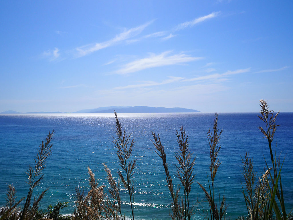 View from Kanali beach across shining blue sea to Zakynthos island. Copyright ©2019 mapandfamily.com 