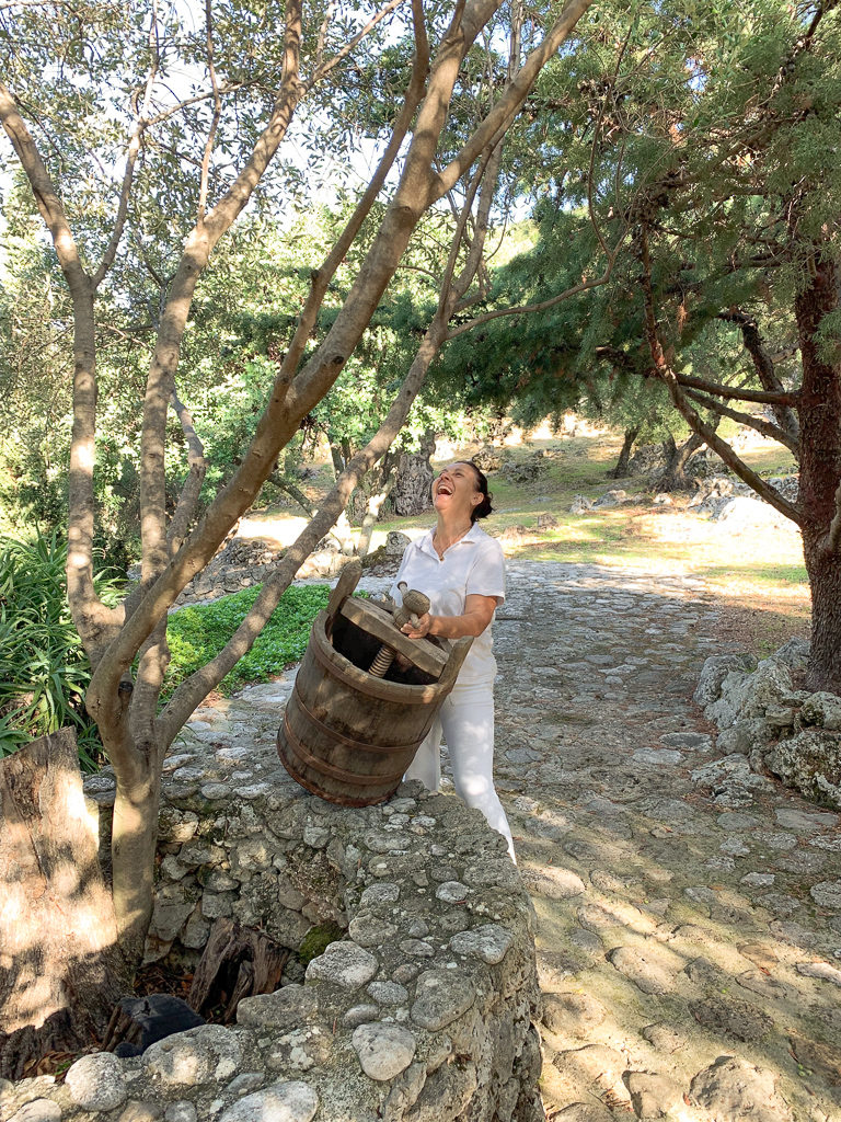 Kefalonia villa with cook. Yolanda laughing in olive grove. Copyright ©2020 mapandfamily.com