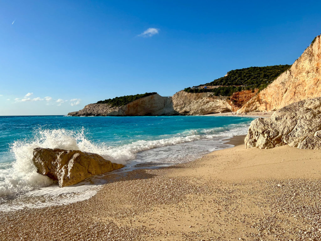 White surf and turquoise waters on pale gold sand and shingle at Porto Katsiki beach, Lefkada. Copyright@ 2022 mapandfamily.com 