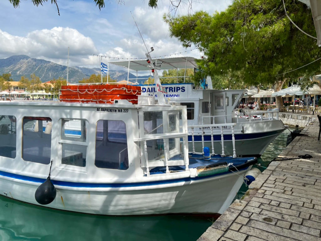 Wooden blue and white excursion boats moored at Vasiliki harbour on Lefkada Greece. Copyright@ 2022 mapandfamily.com 