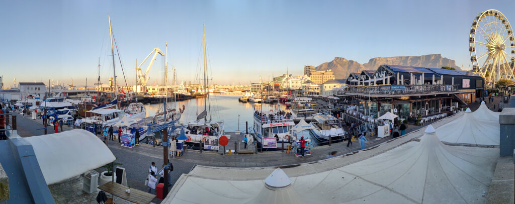 Fun things to do in Cape Town for couples: V&A waterfront panorama showing boats and ferris wheel. Copyright@2023 reserved to photographer via mapandfamily.com 