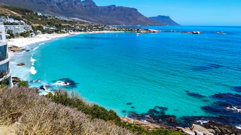 Turquoise sea and white sand with a mountain range behind at Clifton beaches. Copyright@2023 reserved to photographer via mapandfamily.com