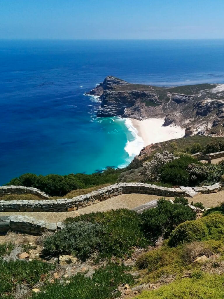 A white sand beach and rocky point of land projecting into sea. Copyright@2023 reserved to photographer via mapandfamily.com 