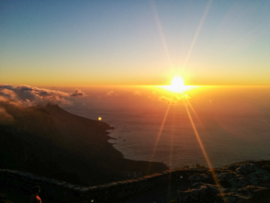 A fun thing to do in Cape Town for couples: viewing the golden sky at sunset from Table Mountain. Copyright@2023 reserved to photographer via mapandfamily.com