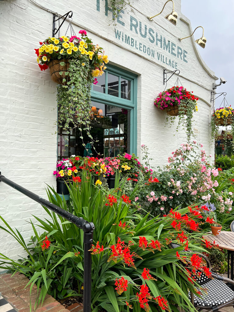 Exterior of The Rushmere pub with colourful hanging baskets of flowers. Copyright@2023mapandfamily.com 