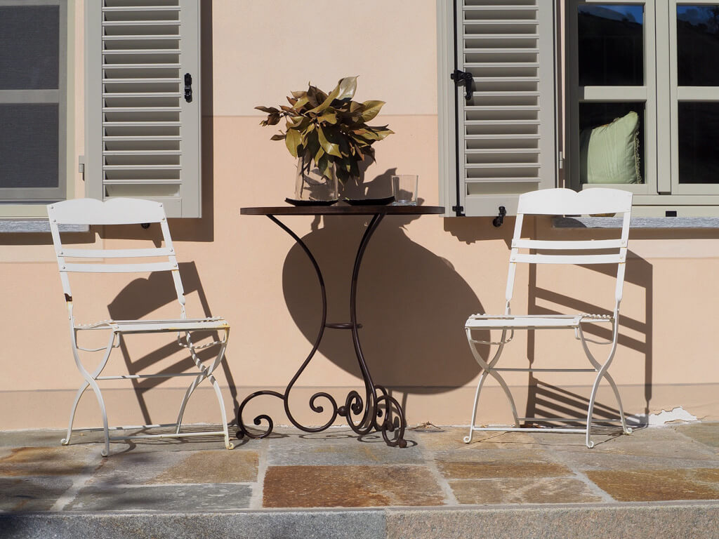 White metal table and two chairs outside Villa Giara boutique Bed and Breakfast in Piedmont. Copyright@2023mapandfamily.com