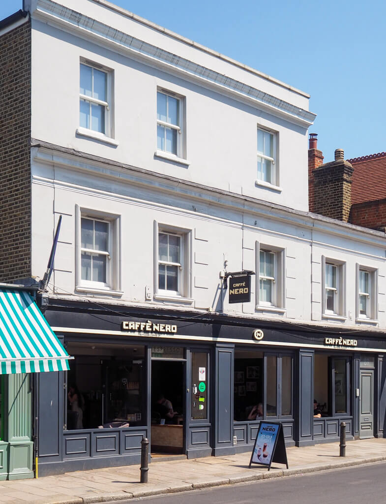 Gallery of two images: a puppy sitting in a leather armchair and the exterior of Caffe Nero, a Wimbledon village cafe. Copyright@2023 mapandfamily.com 