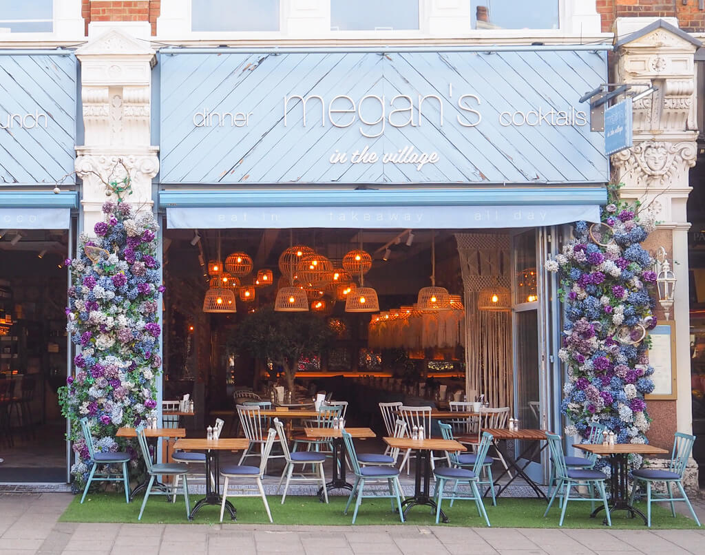 A sunny day at Megan's with doors open wide, and tables on the pavement. Copyright@2024 Nancy Roberts 