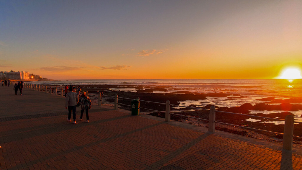 Sunset in shades of orange and gold across coastline and promenade. Copyright@2023 reserved to photographer via mapandfamily.com 