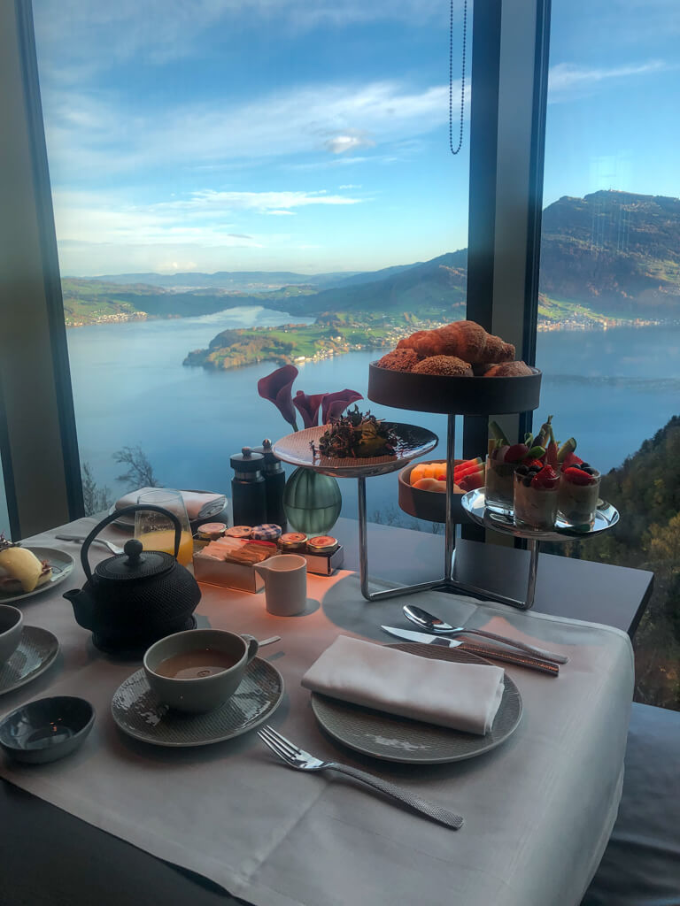 A table set for breakfast looking out from mountain top over lake. Copyright@2023 reserved to photographer via mapandfamily.com 