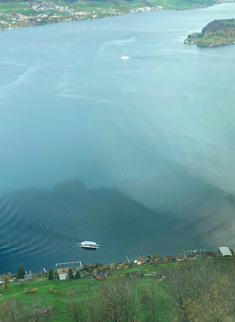 View from mountain ridge of Lake Lucerne beneath with white boat. Copyright@2023 reserved to photographer via mapandfamily.com 