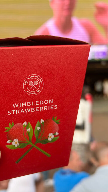 Red box of Wimbledon strawberries in front of screen on Hill. Copyright@2023mapandfamily.com 