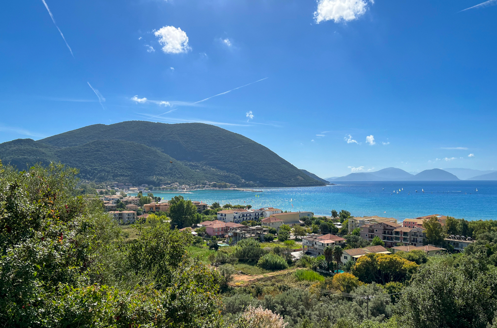 Blue sky and calm blue bay at Vasiliki beach Lefkada. Copyright@2023mapandfamily.com 