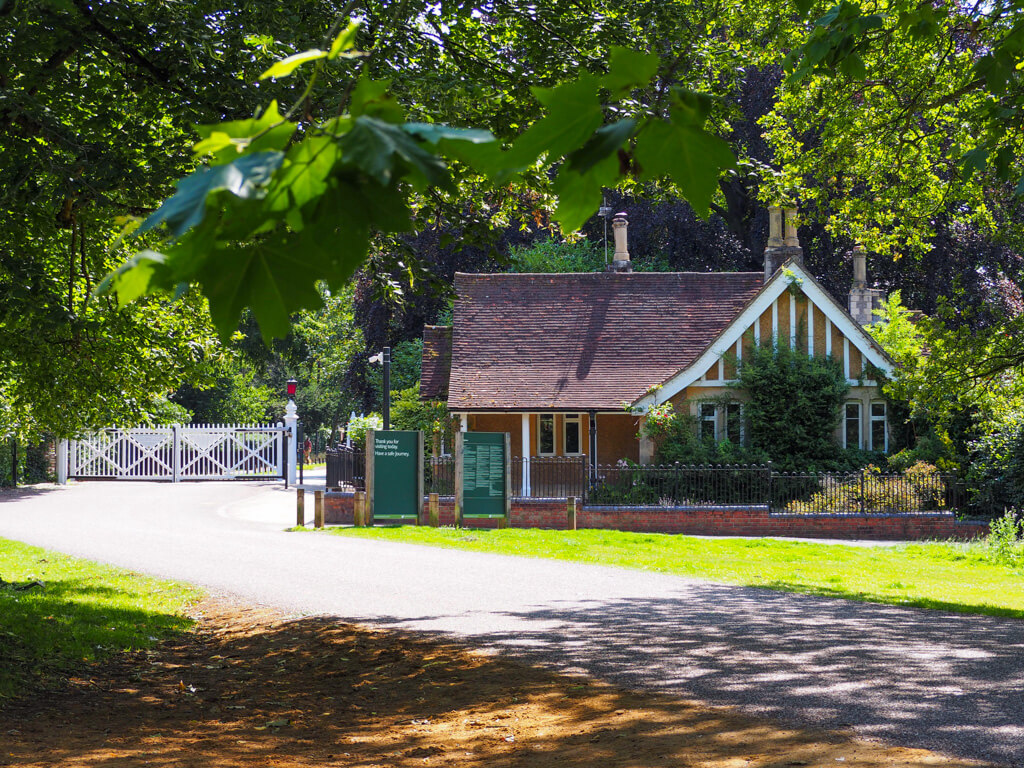 White gates and a gabled gate house at one of the entrances to Windsor Great Park. Copyright@2023 mapandfamily.com