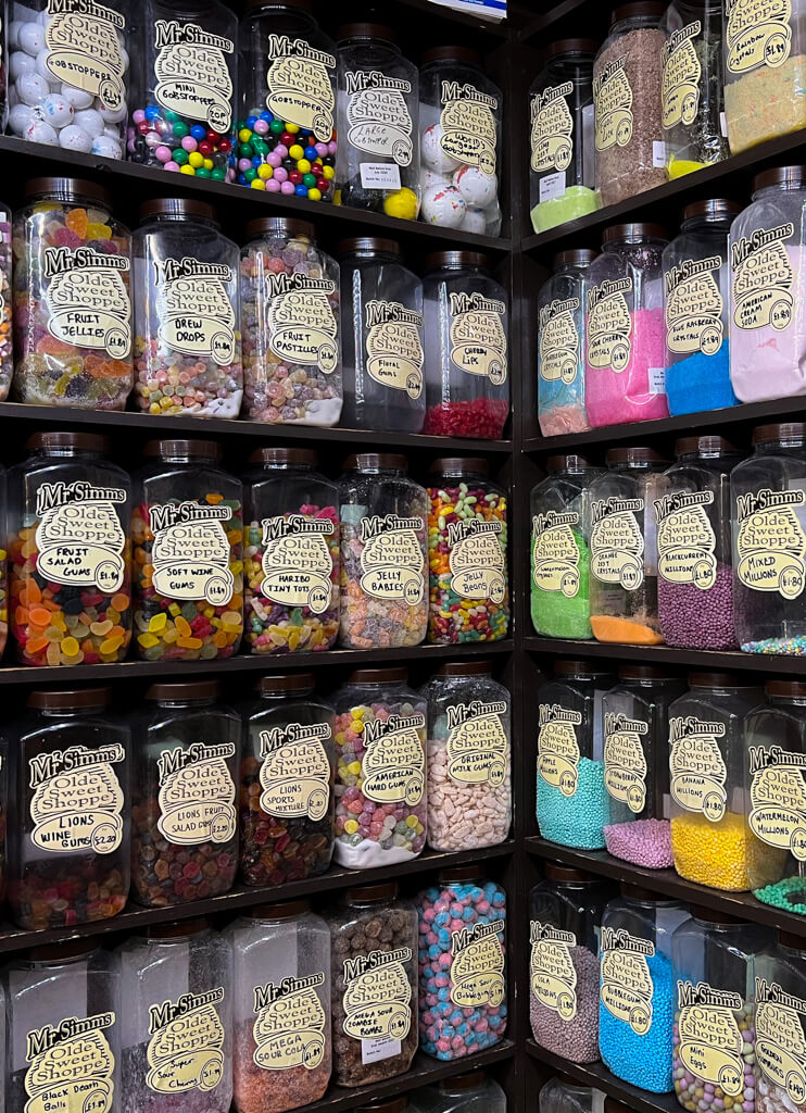 Inside Mr Simms sweet shop showing rows of shelves full of large jars of sweets to be sold by weight. Copyright@2023 mapandfamily.com 