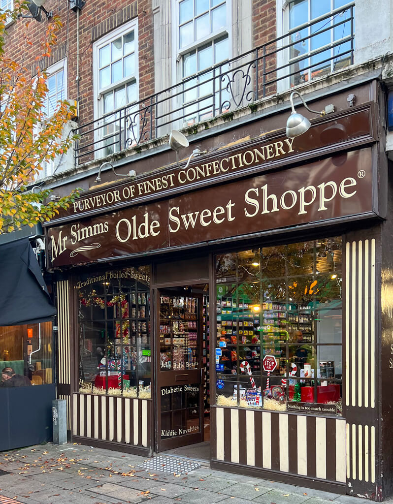 Exterior of Mr Simms sweet shop in a quiet street with confectionery on display in the windows. Copyright@2023 mapandfamily.com 