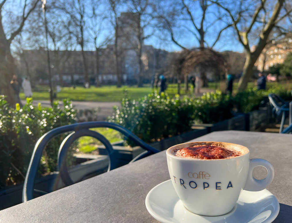 Caffe Tropea Russell Square outdoor terrace with cappuccino in cup with name of cafe. Copyright@2024 mapandfamily.com 