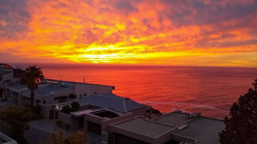 fiery red and orange sunset above rooftops. Copyright@2024 reserved to photographer via mapandfamily.com 