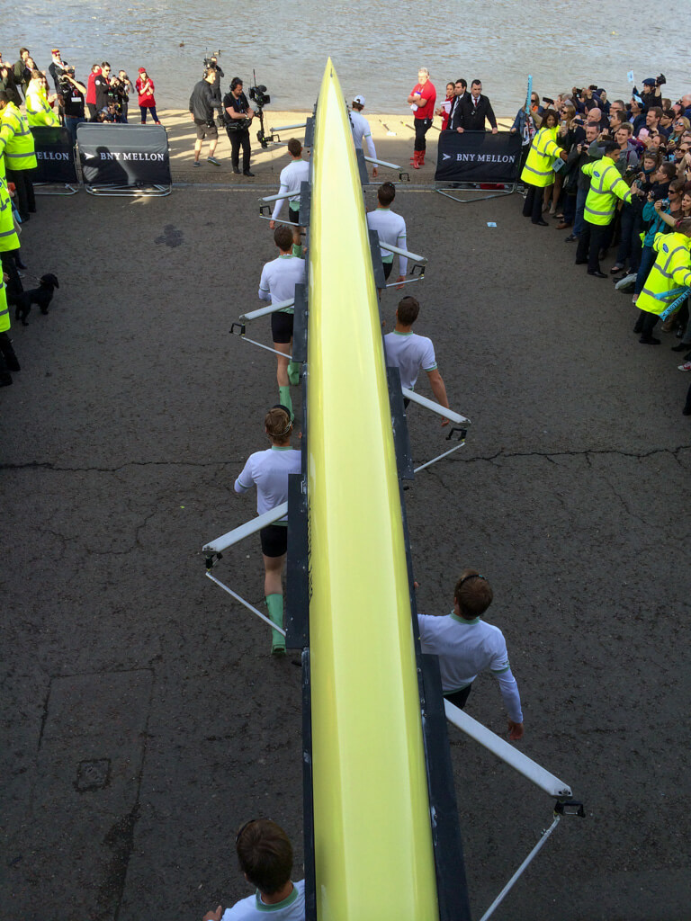 Boat race crew carrying hull to water. Copyright@2024mapandfamily.com 