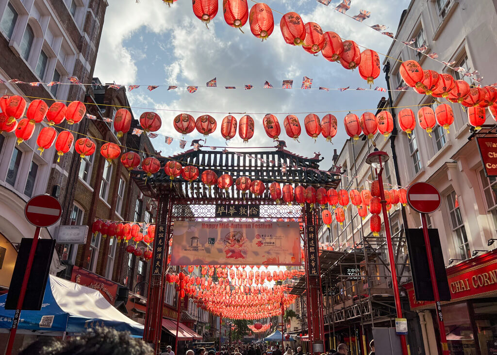 Red lanterns strung high across the street in London's Chinatown. Copyright@2024NancyRoberts