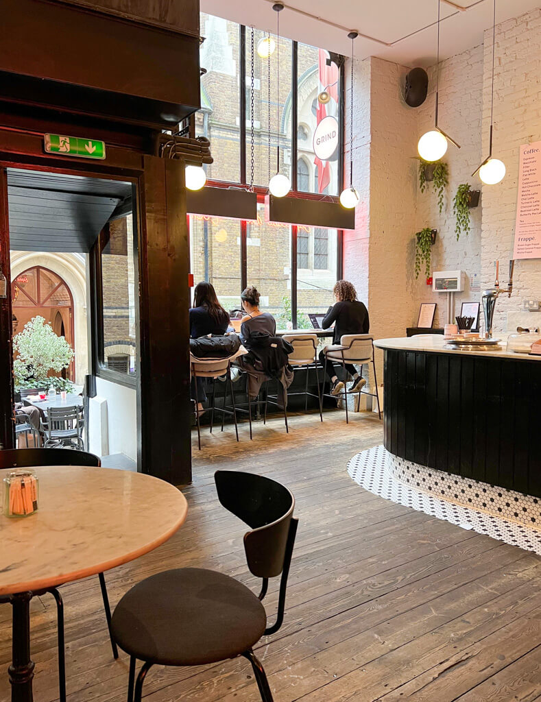 Interior of Covent Garden Grind with customers sitting in the window, working on laptops. Copyright@2024mapandfamily.com 