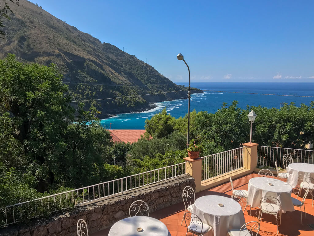 The deep blue sea contrasting against terracotta tiles on the dining terrace of Hotel Villa Cheta Copyright@2024 reserved to the photographer via mapandfamily.com 