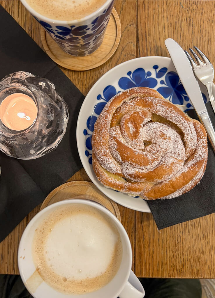 Candle, cup of coffee and sugared roll. Copyright@2024mapandfamily.com 