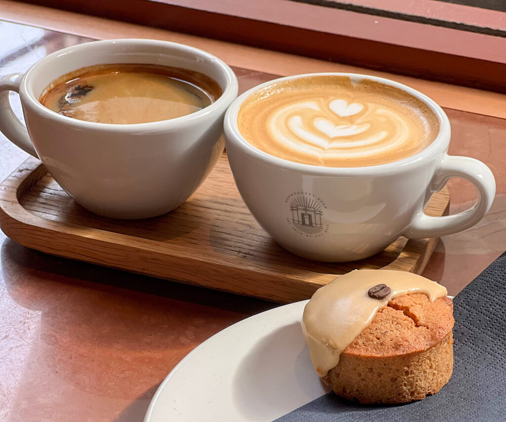 Covent Garden coffee shop with two cups of coffee on tray with cake. Copyright@2024mapandfamily.com