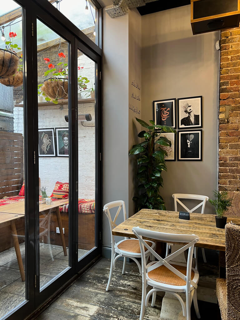 Interior of Mibaj Paddington cafe showing glass doors leading to a small covered terrace. Copyright@2024 mapandfamily.com