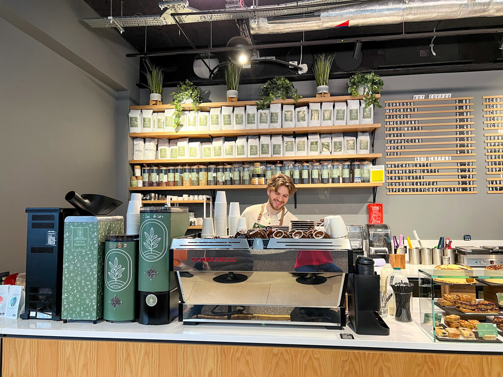 Interior of Paddington coffee shop Treelogy, showing the steel coffee machine and shelves of own blend coffee. Copyright@2024 mapandfamily.com