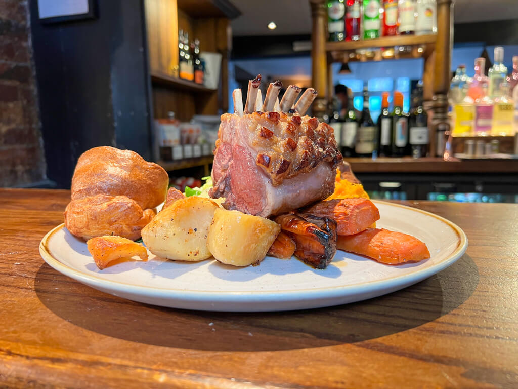 A dish of rack of lamb with Yorkshire puddings and vegetables. Copyright@2024 Nancy Roberts