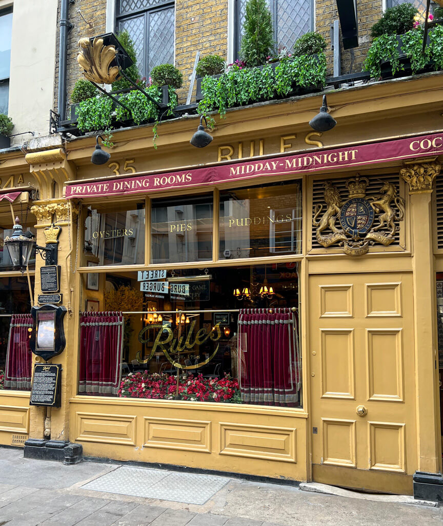 Mustand-yellow facade of Rules in London's Covent Garden. Copyright@2024NancyRoberts