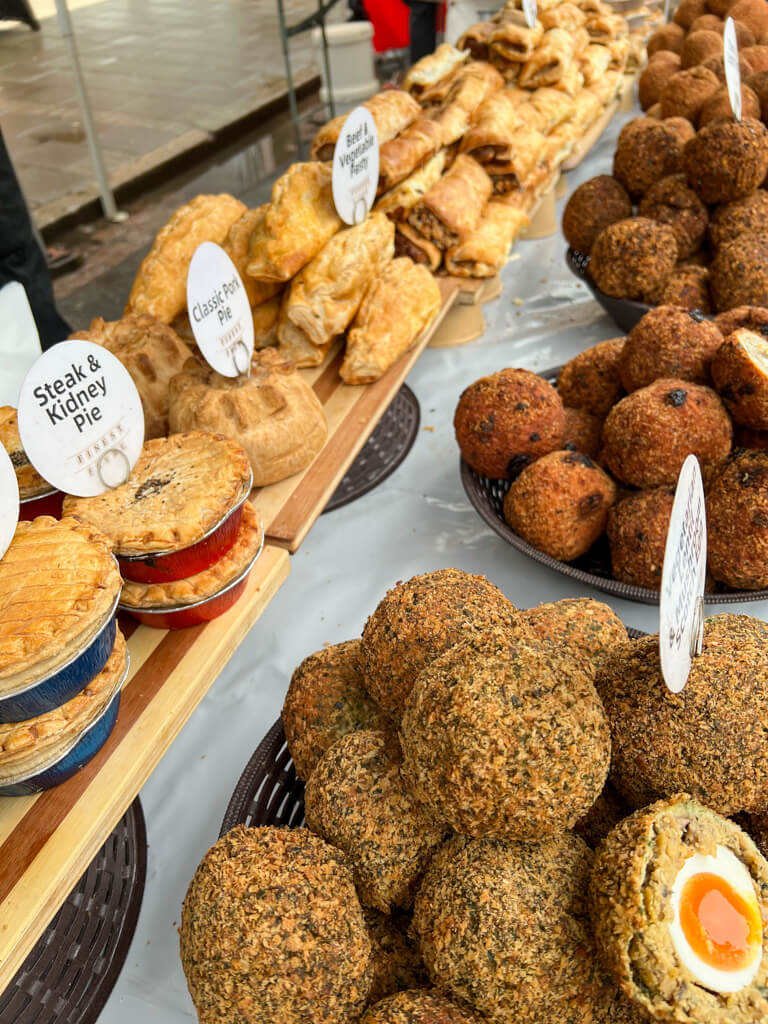 A food stall in a London market with pies, sausage rolls and Scotch eggs on display. Copyright@2024NancyRoberts