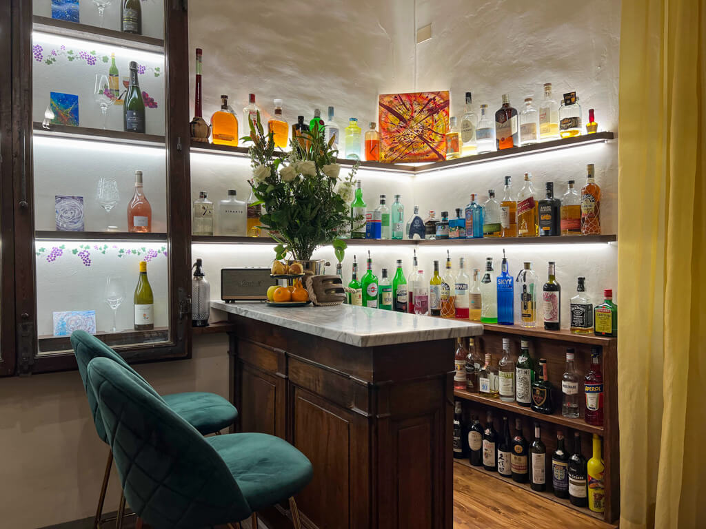 A cosy bar with a small counter and shelves of spirits in the hotel. Copyright@2024 NancyRoberts 